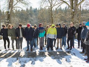 Die Schüler vor einer steinernen Schwelle mit den Namen der Einrichtungen, aus denen Menschen zur Tötung nach Grafeneck gebracht wurden.